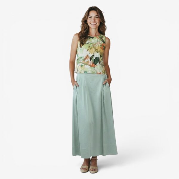 Bild 1: Frau trägt Midi-Rock Momyro von Fox’s Mode in Beige, Vorderansicht, A-Linie mit Falten, kombiniert mit floralem Crop-Top Bild 2: Frau trägt Midi-Rock Momyro von Fox’s Mode in Salbeigrün, Vorderansicht, Hände in Taschen, kombiniert mit floralem Crop-Top Bild 3: Frau trägt Midi-Rock Momyro von Fox’s Mode in Salbeigrün, Vorderansicht, entspannte Pose, kombiniert mit floralem Crop-Top Bild 4: Frau trägt Midi-Rock Momyro von Fox’s Mode in Beige, Dreiviertelansicht, Eingriffstasche sichtbar, kombiniert mit floralem Crop-Top Bild 5: Seitenansicht Midi-Rock Momyro von Fox’s Mode in Hellgrün, schwungvolle A-Linie und Falten gut sichtbar, kombiniert mit floralem Crop-Top