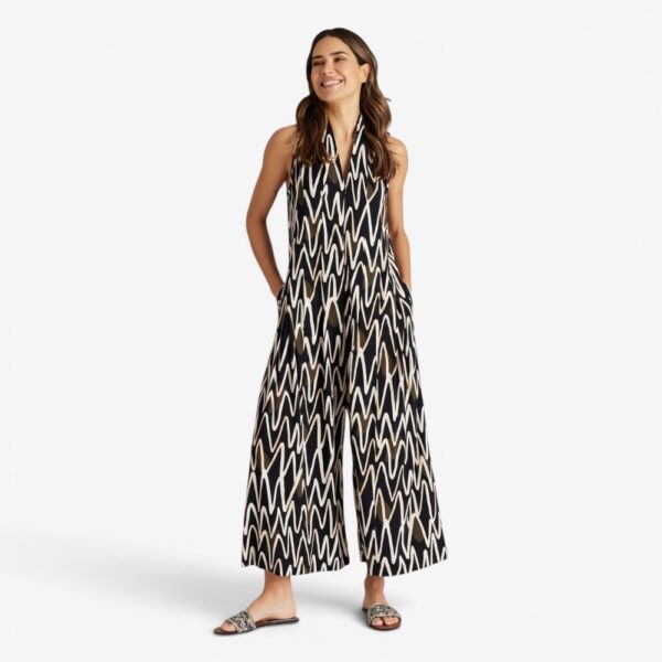 Bild 1 (Detailaufnahme Tasche/Muster): Detailansicht Jumpsuit VUQOQUAI von Fox’s Mode – grafisches Zickzack-Muster in Schwarz und Creme, Seitentasche sichtbar Bild 2 (Frontansicht Oberteil/Gesicht): Jumpsuit VUQOQUAI von Fox’s Mode – eleganter Stehkragen mit V-Ausschnitt, grafisches Muster, ärmellos Bild 3 (Rückenansicht Oberteil): Jumpsuit VUQOQUAI von Fox’s Mode – rückenfreier ärmellos Schnitt mit Stehkragen, Rückenansicht Bild 4 (Sitzende Pose seitlich): Legerer Jumpsuit VUQOQUAI von Fox’s Mode in Schwarz mit Zickzack-Print, Seitenansicht sitzend Bild 5 (Rückenansicht ganzkörper): Jumpsuit VUQOQUAI von Fox’s Mode – Ganzkörper Rückenansicht, weiter Palazzo-Schnitt, schwarzes Zickzack-Muster Bild 6 (Frontansicht ganzkörper): Legerer Jumpsuit VUQOQUAI aus Viskose von Fox’s Mode – Ganzkörper Frontansicht, Schwarz gemustert, Größen 34–40 Meta-Beschreibung Der Jumpsuit VUQOQUAI von Fox’s Mode überzeugt mit fließender Viskose, grafischem Zickzack-Muster und lässigem Palazzo-Schnitt. Jetzt in Schwarz entdecken Größen 34 bis 40.