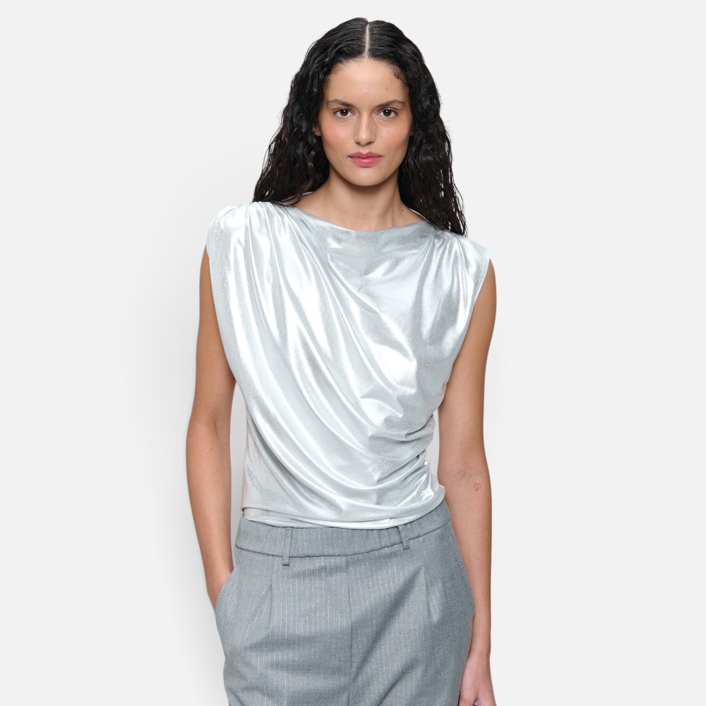 • Bild 1: Frau trägt silbernes glänzendes Nelly Top mit Schulterfalte, Nahaufnahme Oberkörper • Bild 2: Frontalansicht des Nelly Tops kombiniert mit grauer Nadelstreifenhose • Bild 3: Rückansicht des glänzenden Tops, Frau in Gesamtlook • Bild 4: Freigestellte Produktansicht des Nelly Tops in Silber