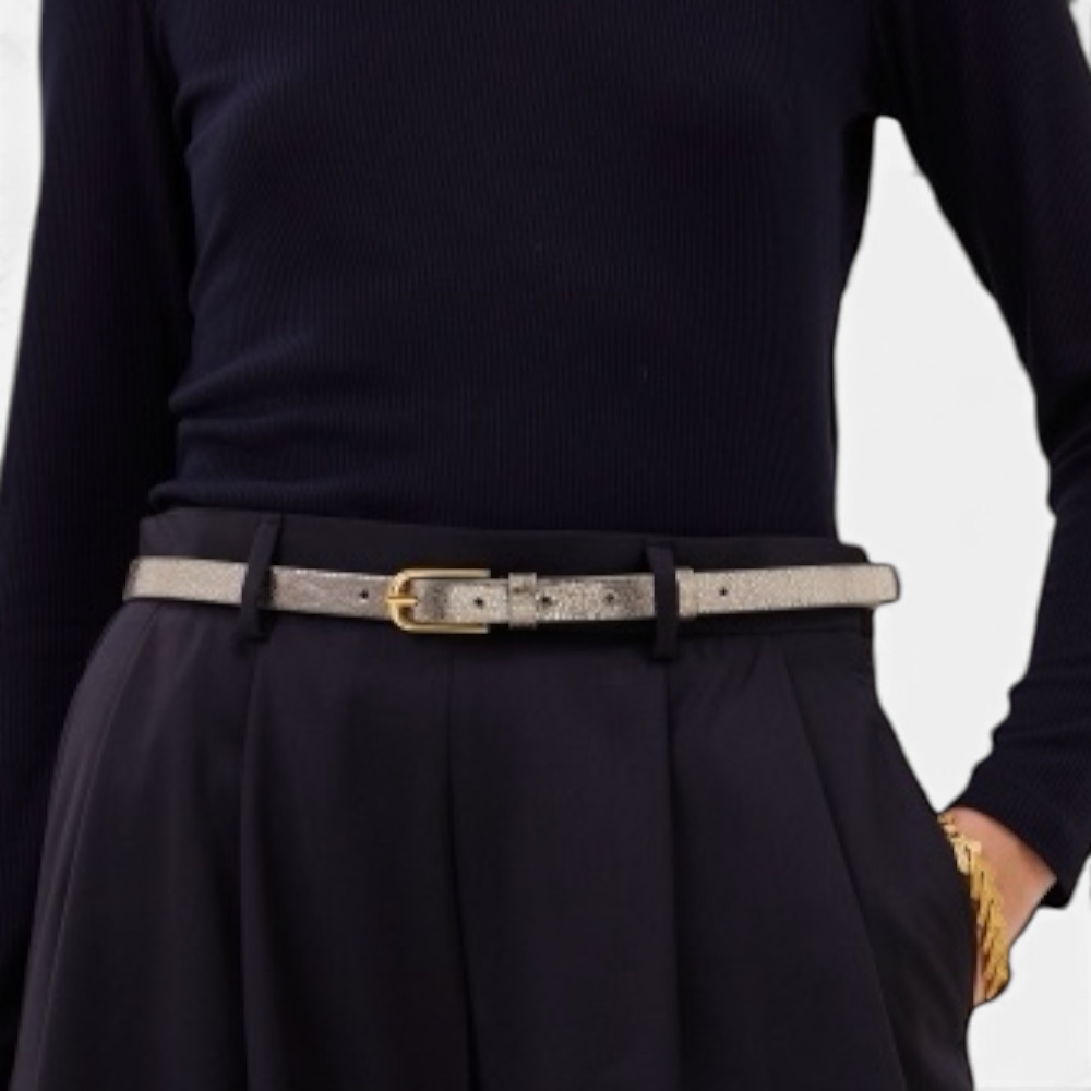 • Detailaufnahme schmaler Metallic-Gürtel an Bundfaltenhose, Nahaufnahme Taille • Metallic Ledergürtel in Gold, Detailaufnahme Taille am Rock • Frau in Rollkragenpullover mit goldenem Metallic-Gürtel, Nahaufnahme • Metallic Ledergürtel freigestellt mit Goldschließe