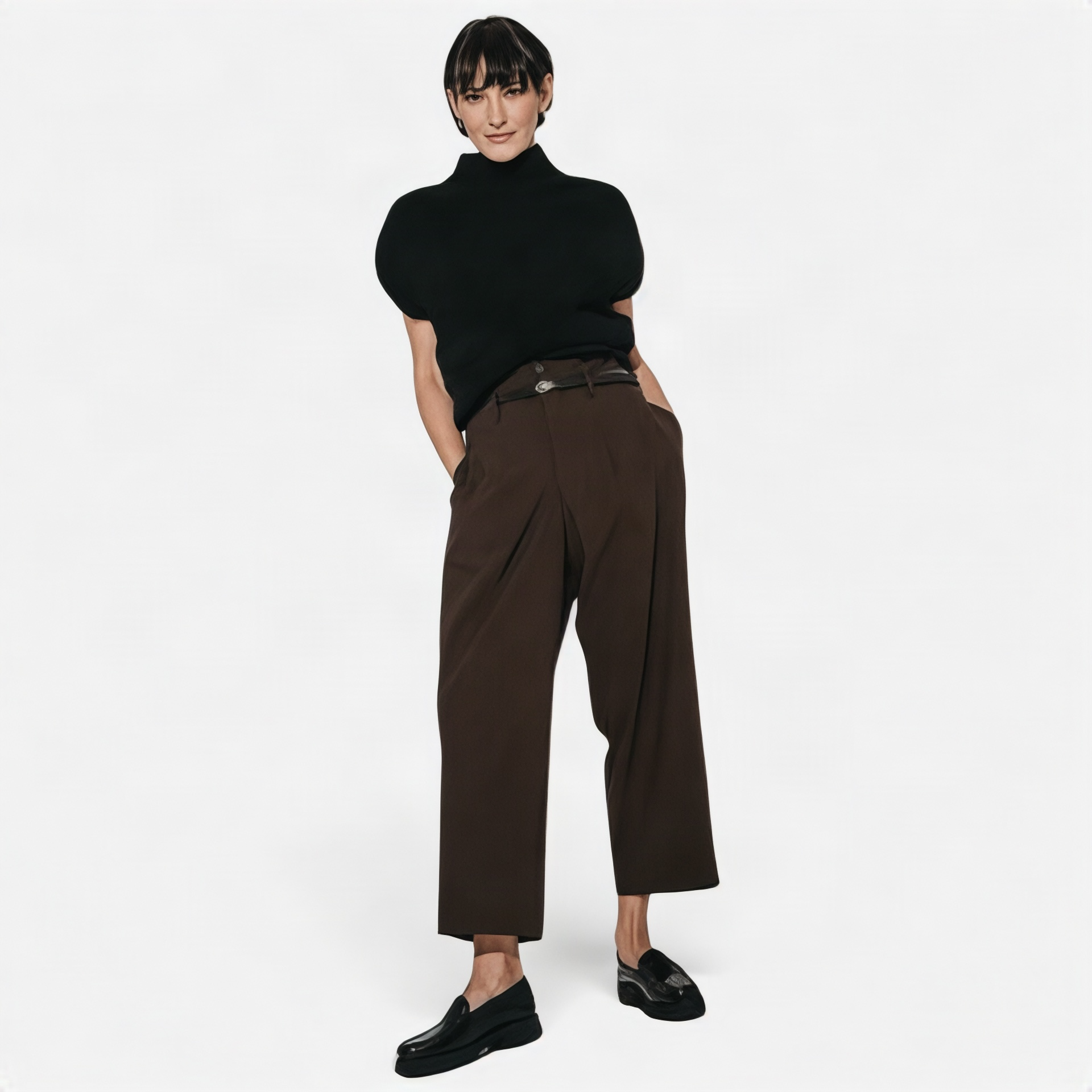 • Frau in brauner High Waist Hose mit Bouclé-Top, Ganzkörperansicht • Frau in schwarzer High Waist Hose mit Bouclé-Top, • Detailaufnahme Bund und Taillengürtel der Jane Lushka Hose • Rückansicht schwarze Hose mit Bundfalten und Gürtel • Frontansicht Hosenbund mit Knopfverschluss und Gürtelschließe • Frau in schwarzer weiter Hose, komplettes Outfit stehend
