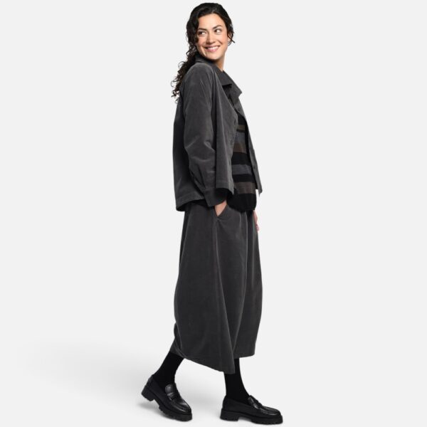 Bild 1 (Komplett-Look mit Jacke): Modell trägt anthrazitfarbenen Vetono Bouleform Rock 9654-035 kombiniert mit passender dunkler Jacke und gestreiftem Pullover Bild 2 (Look mit Streifenpullover): Lässiges Herbst-Outfit mit weitem gestreiftem Strickpullover wadenlangem Vetono Ballonrock anthrazit und schwarzen Loafern Bild 3 (Frontansicht Detail Bund): Anthrazitfarbener Damen Schlupfrock von Vetono mit breitem elastischem Dehnbund und Hand in der Seitentasche Frontansicht Bild 4 (Studio-Produktbild): Vetono Midi Rock in O-Silhouette aus elastischem Baumwoll-Viskose-Mix freigestellt auf weißem Hintergrund