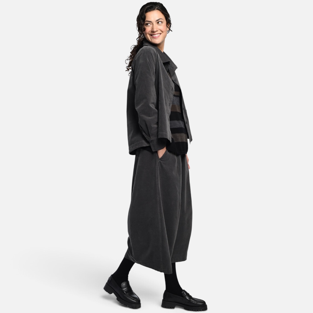 Bild 1 (Komplett-Look mit Jacke): Modell trägt anthrazitfarbenen Vetono Bouleform Rock 9654-035 kombiniert mit passender dunkler Jacke und gestreiftem Pullover Bild 2 (Look mit Streifenpullover): Lässiges Herbst-Outfit mit weitem gestreiftem Strickpullover wadenlangem Vetono Ballonrock anthrazit und schwarzen Loafern Bild 3 (Frontansicht Detail Bund): Anthrazitfarbener Damen Schlupfrock von Vetono mit breitem elastischem Dehnbund und Hand in der Seitentasche Frontansicht Bild 4 (Studio-Produktbild): Vetono Midi Rock in O-Silhouette aus elastischem Baumwoll-Viskose-Mix freigestellt auf weißem Hintergrund
